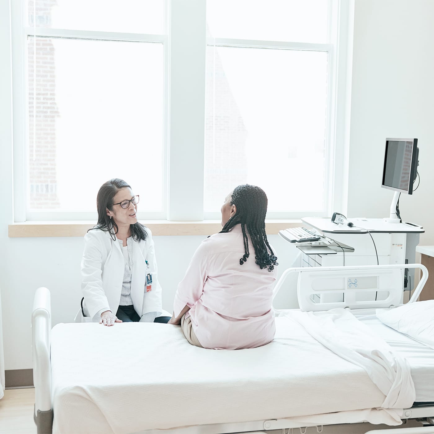 A patient and doctor having a bedside discussion in a hospital setting